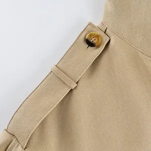 Detailed close-up of the button and waist belt on a khaki velvet windbreaker coat.