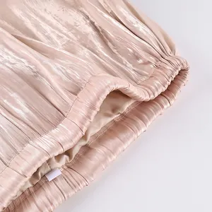 Close-up detail of the pink pleated elastic waistband on comfortable loose lantern pants