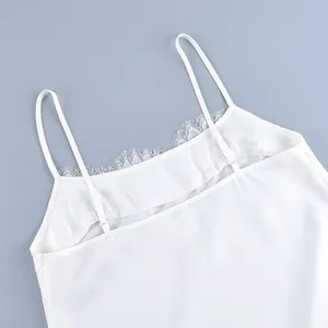 Detailed macro view showing delicate lace trim and adjustable thin straps on a white camisole