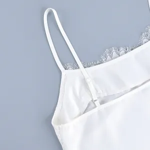 Detailed macro view of white camisole featuring delicate lace trim and adjustable straps