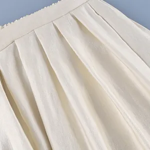 Close-up of elegant cream satin lantern pants featuring delicate pleated waist details.