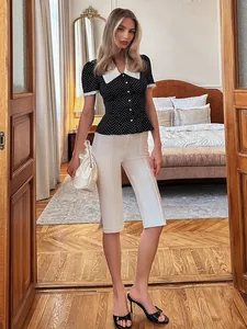 Elegante camicetta a pois bianchi e neri con colletto Peter Pan bianco e vita stretta