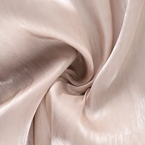 Close-up macro view of the shiny champagne fabric texture for casual lantern pants.