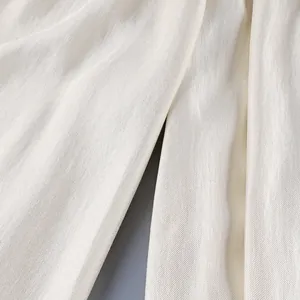 Detailed macro view of the cream satin fabric showing its elegant drape and fine texture.