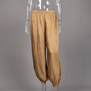 Close-up of champagne gold lantern pants with silky metallic texture and loose fit