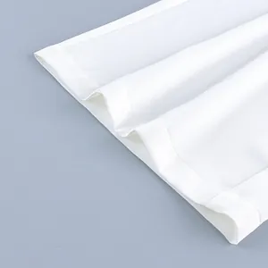 Close-up of white straight-leg pants hem showing clean stitching and fabric texture
