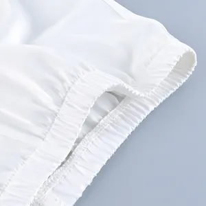 Close-up detail of the elastic waistband on a white satin casual two-piece fashion set.