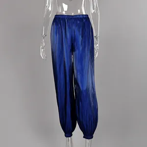 Detail view of blue loose lantern pants with elastic waist and shiny fabric texture