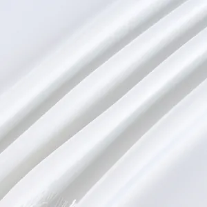 Detail shot of luxurious white satin fabric texture for an elegant two-piece clothing set
