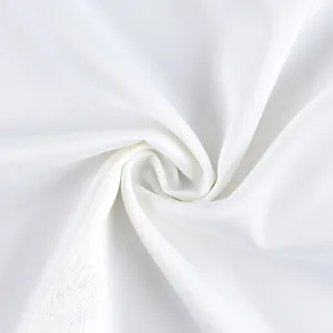 Macro view of the soft white fabric and lace detail of the elegant commuting suit set