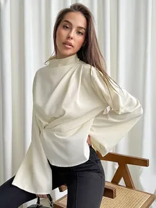 Close-up detail of an elegant apricot chiffon blouse featuring a draped waist and high neck design