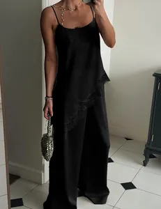 Close-up detail of lace trim on black satin camisole top and wide-leg trouser set