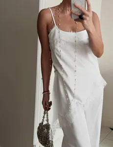 Elegant white satin two-piece set featuring a lace-trimmed camisole and straight pants.