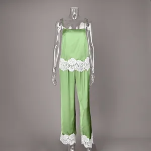 Detailed view of green satin pajamas set with white lace trim on camisole and pants