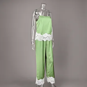 Detailed view of a green satin pajama set featuring white floral lace hem and camisole.
