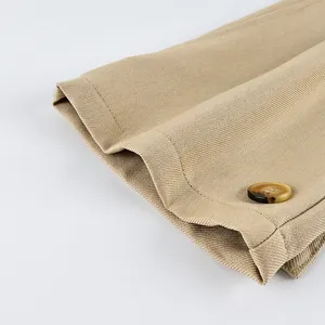 Detailed macro view of khaki frosted velvet fabric and tortoiseshell button on coat sleeve