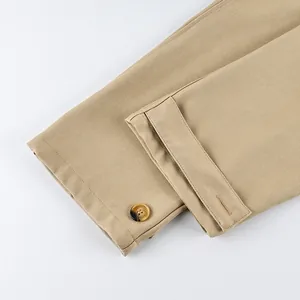 Detailed macro view of khaki frosted velvet trench coat sleeve cuff and button tab design