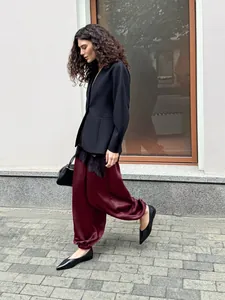 Vista dettagliata di eleganti pantaloni harem in raso bordeaux da donna stile street