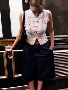 Élégant haut sans manches en dentelle blanche avec boutons chinois et col montant chic.