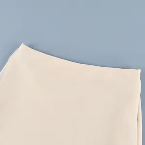 Vista detallada de la falda de satén crema con diseño elegante de malla transparente