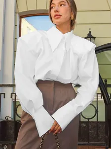 Détail d'une chemise blanche professionnelle avec épaules structurées et larges poignets