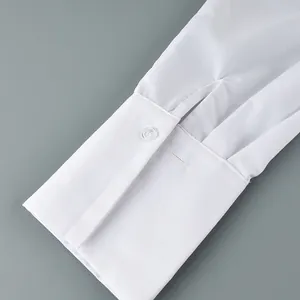 Gros plan d'un poignet de chemise blanc avec des plis élégants pour un look de bureau.
