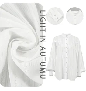 Detailed macro view of white cotton French blouse showing fabric texture and lantern sleeve