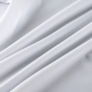 Gros plan sur la texture du tissu blanc impeccable et les plis souples de la chemise