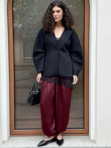 Outfit donna stile europeo con giacca nera a maniche a sbuffo e pantaloni larghi bordeaux