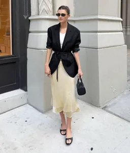 Elegante falda midi de satén con bajo de malla transparente en un look street style.