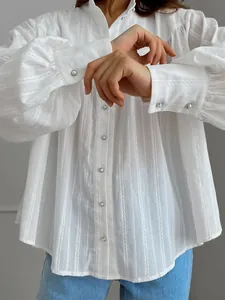Close-up of a white cotton French style shirt with puff sleeves and pearl buttons