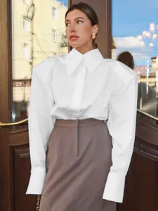 Détail d'un chemisier blanc de bureau pour femme avec des épaules surdimensionnées