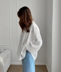 Side view of a white French cotton shirt with textured stripes and loose bubble sleeves.