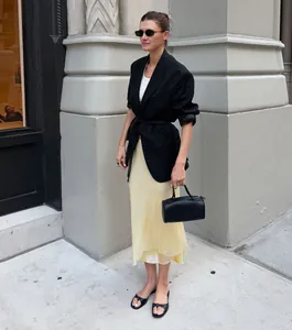 Elegante falda midi de satén amarillo pálido con patchwork de malla, estilo urbano.