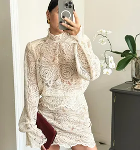 Detail view of elegant cream lace two-piece set featuring long sleeve blouse and skirt