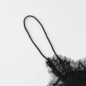 Détail rapproché montrant la bordure en dentelle noire raffinée et la fine bretelle d'une robe