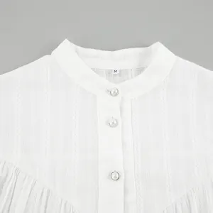 Close-up of white French cotton blouse featuring mandarin collar and pearl buttons