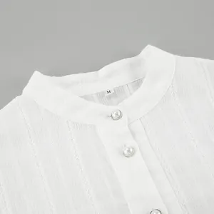 Close-up of a white French shirt collar featuring elegant pearl buttons and texture