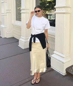 Elegante falda midi de satén champán con detalle de dobladillo de malla transparente