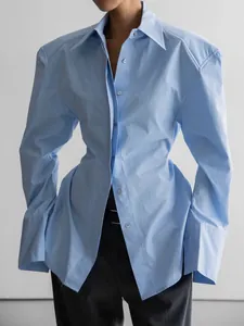 Chemise bleue à manches longues avec épaules structurées et taille cintrée élégante