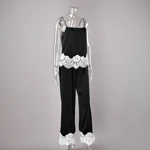 Detailed view of black satin pajama set with white floral lace trim on mannequin