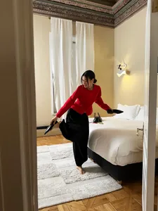 Elegant high-waisted black satin baggy lantern pants shown in a cozy bedroom scene
