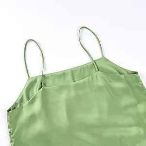 Detail of a light green satin camisole top with thin straps and a smooth finish