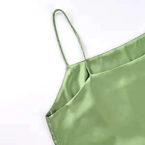Close-up of light green satin camisole with thin spaghetti strap and smooth finish.