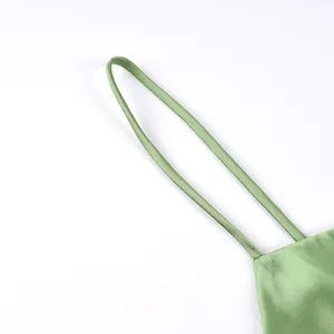 Close-up detail of slim shoulder strap on light green satin camisole top