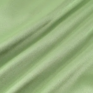 Close-up macro detail of breathable sage green fabric with subtle linen texture
