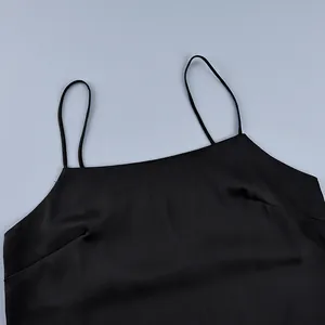 Close-up detail of black spaghetti straps and smooth satin fabric on a camisole top.