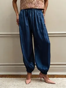 Detailed view of dark blue satin lantern pants featuring smooth silk-like texture and sheen