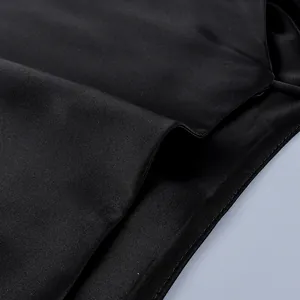 Detailed macro view of black satin fabric texture and stitching for clothing set