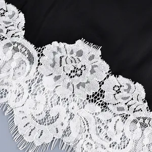 Detailed close-up showing the intricate white floral lace trim and eyelash edges on black top